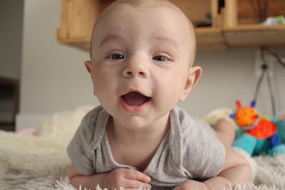 Portrait of cute baby boy lying on bed at home