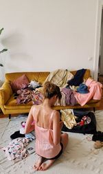 Rear view of woman packing her suitcase at home