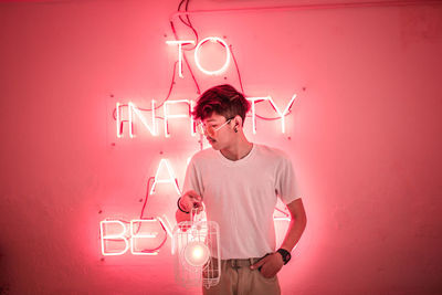 Full length of man standing against pink wall