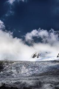 View of snow covered landscape against cloudy sky