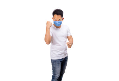 Portrait of young man standing against white background