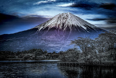 Scenic view of lake by mountain against sky