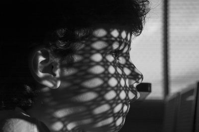 Close-up of boy with shadow on face looking away