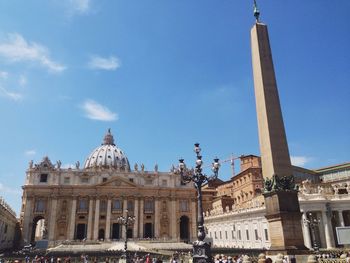 Low angle view of saint peters basilica and memorial column against blue sky