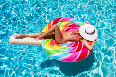 High angle view of child floating in swimming pool