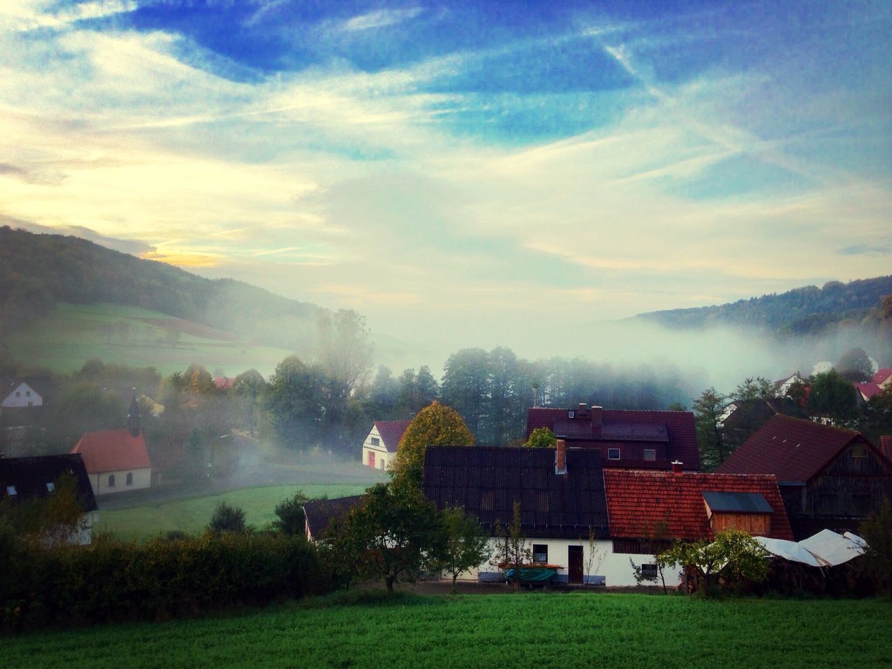 building exterior, architecture, built structure, sky, grass, house, landscape, tree, beauty in nature, field, mountain, cloud - sky, scenics, tranquil scene, nature, green color, tranquility, residential building, residential structure, residential district