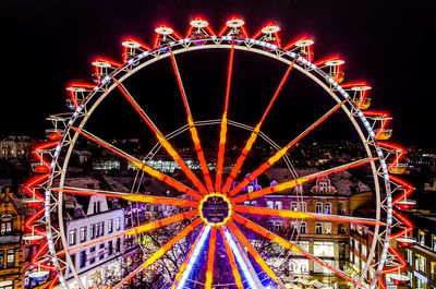 Low angle view of illuminated ferris wheel against sky at night