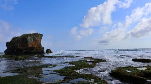 Rocks on sea shore against sky