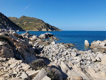 Scenic view of rocks on beach against clear sky