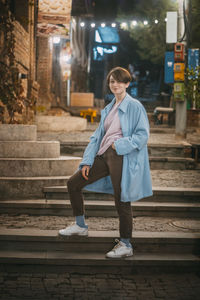 Full length of woman standing on staircase in city