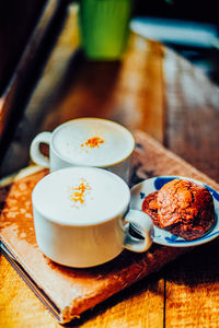 Two coffee cup of cappuccino and brownie cookies on the wooden table ,street coffee, top view.