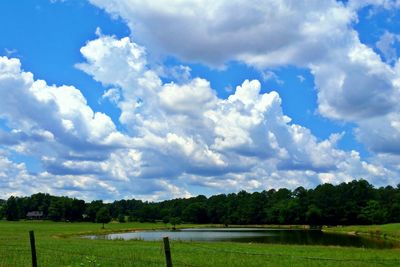 Scenic view of grassy field against cloudy sky