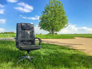 Chair on field against sky