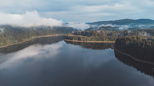 View of untouched nature from above. mixed forest and lake under morning mist and sunrise