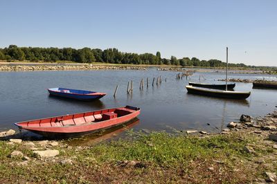 Boat moored on shore against sky