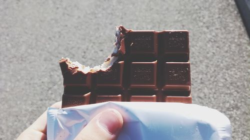 Close-up of hand holding chocolate cake