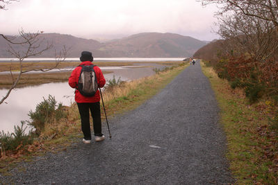 Rear view of man walking on road