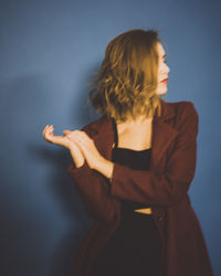 Midsection of woman standing against wall