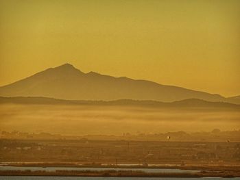 Scenic view of field against orange sky