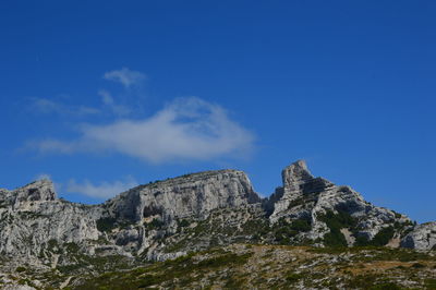 Low angle view of mountain against blue sky