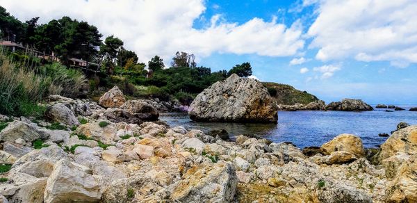 Panoramic view of rocks on beach against sky