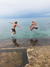 Woman enjoying in sea against sky