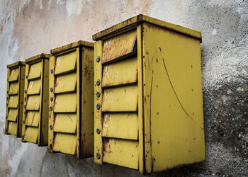 Close-up of yellow mailbox on wall