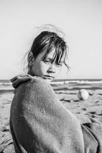 Portrait of girl standing at beach against clear sky