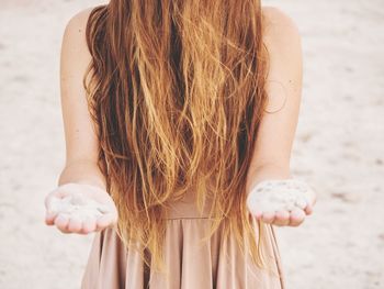 Rear view of woman standing at beach