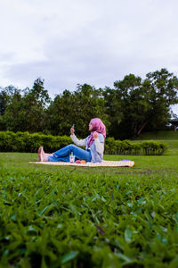 Rear view of couple on field against sky