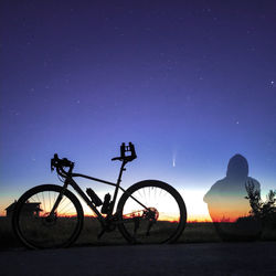 Silhouette bicycle against clear sky at night