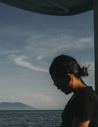 Portrait of woman looking at sea against sky