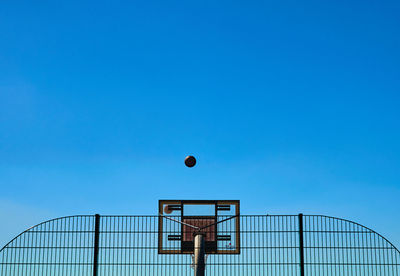 Low angle view of basket ball against clear blue sky