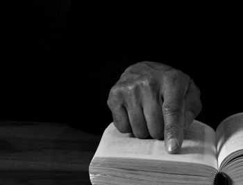 Cropped hand of man holding book