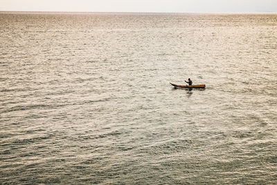 Man on boat in sea against sky