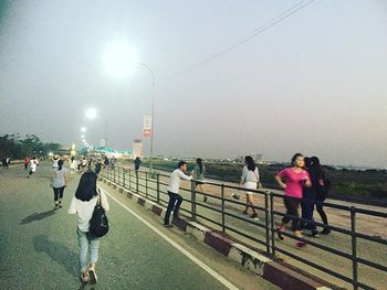 People on railing against sky