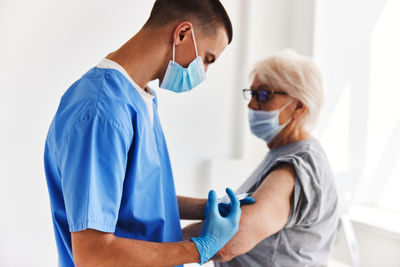 Side view of female doctor examining patient at clinic