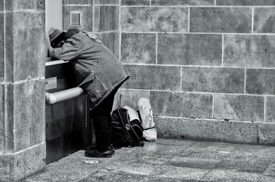 Midsection of man standing against wall