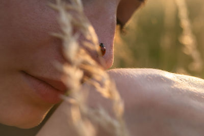 Young woman playing with a cute ladybug in the nature at sunset. back to the nature concept. 