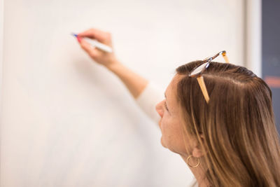 Businesswoman writing on whiteboard in office