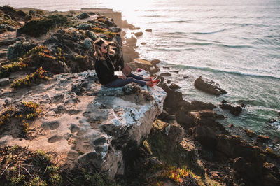 Man sitting on rock at beach