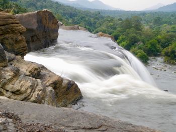 Scenic view of waterfall against sky