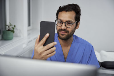 Male doctor having online consultation on smart phone