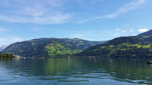 Scenic view of lake by mountains against sky