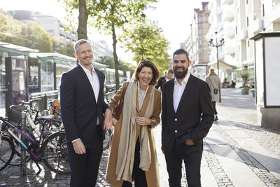 Smiling colleagues walking in street