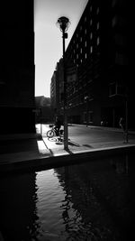 Man walking on street light against sky