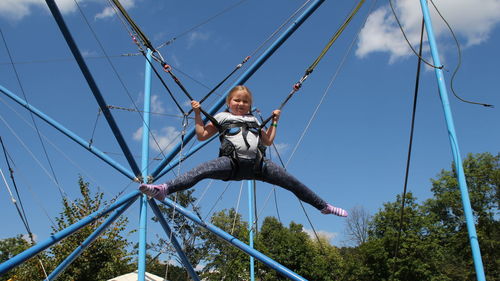 Low angle view of man on rope against sky