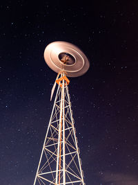 Low angle view of communications tower against sky at night