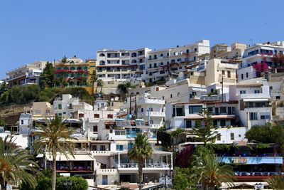 Buildings in city against clear blue sky