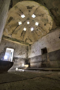 Low angle view of illuminated ceiling in abandoned building